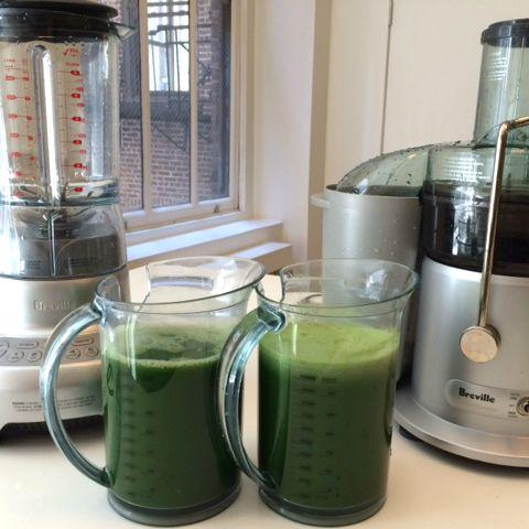 Two pitchers of freshly made green juice placed beside a juicer and blender on a kitchen counter, highlighting a healthy juicing routine from a health and wellness ebook.