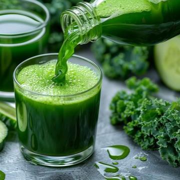 A glass of fresh green juice being poured from a bottle, surrounded by kale and other green ingredients, promoting healthy juicing for wellness